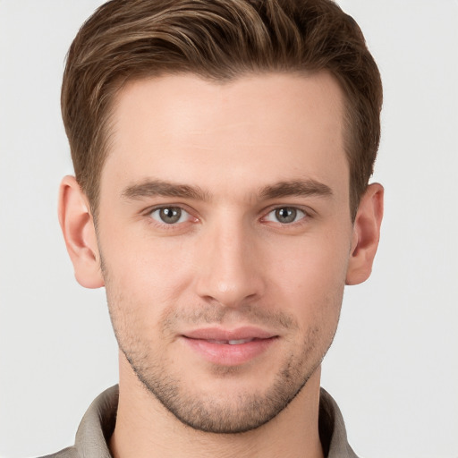 Joyful white young-adult male with short  brown hair and grey eyes