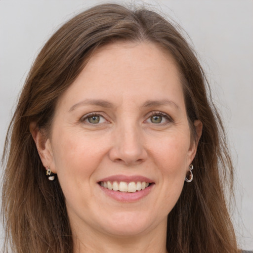 Joyful white adult female with long  brown hair and grey eyes