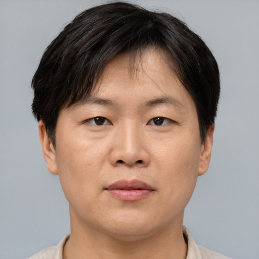 Joyful asian adult male with short  brown hair and brown eyes