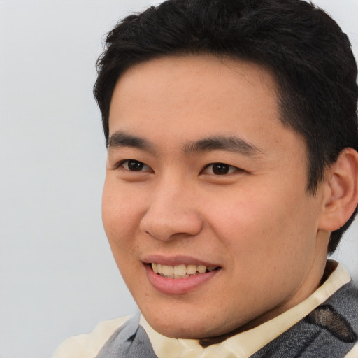 Joyful asian young-adult male with short  brown hair and brown eyes