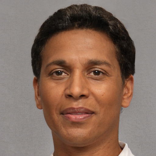 Joyful black adult male with short  brown hair and brown eyes
