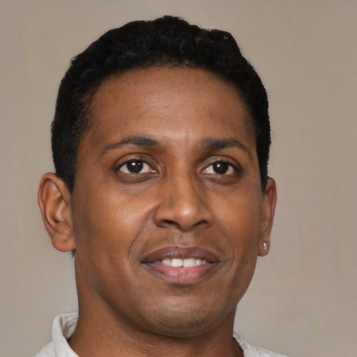 Joyful black young-adult male with short  brown hair and brown eyes