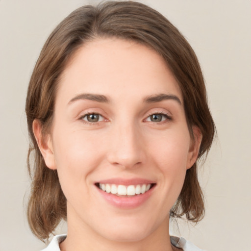 Joyful white young-adult female with medium  brown hair and green eyes