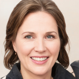 Joyful white adult female with medium  brown hair and grey eyes