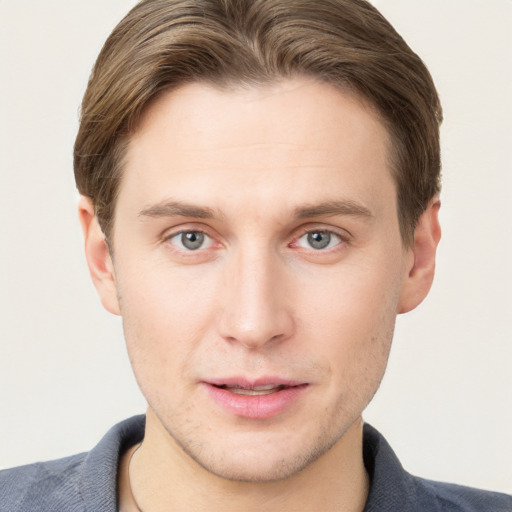 Joyful white young-adult male with short  brown hair and grey eyes