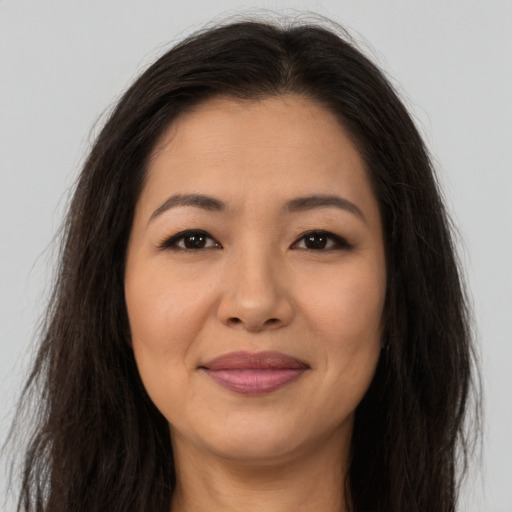 Joyful asian young-adult female with long  brown hair and brown eyes