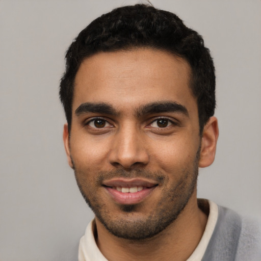 Joyful latino young-adult male with short  black hair and brown eyes