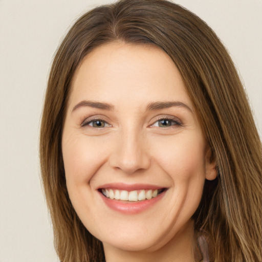 Joyful white young-adult female with long  brown hair and brown eyes