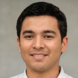 Joyful latino young-adult male with short  black hair and brown eyes