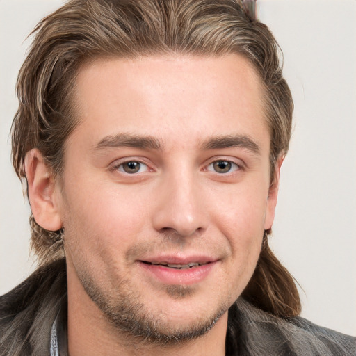 Joyful white young-adult male with short  brown hair and grey eyes