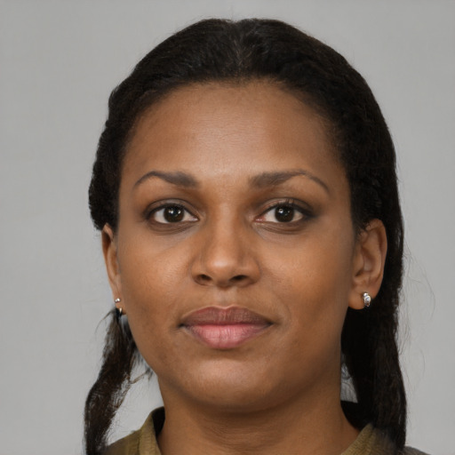 Joyful black young-adult female with long  brown hair and brown eyes