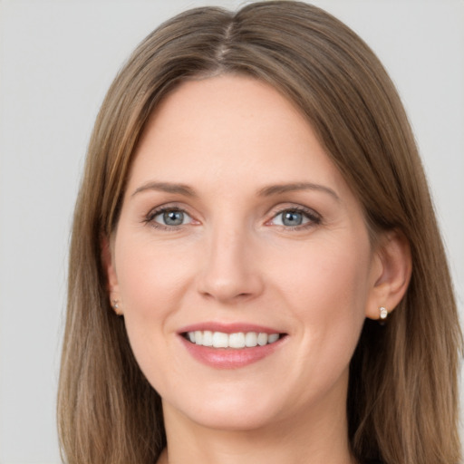 Joyful white young-adult female with long  brown hair and grey eyes