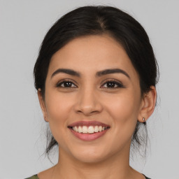 Joyful latino young-adult female with medium  brown hair and brown eyes