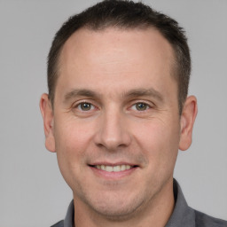 Joyful white adult male with short  brown hair and grey eyes