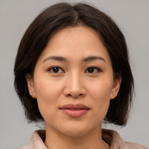 Joyful asian young-adult female with medium  brown hair and brown eyes