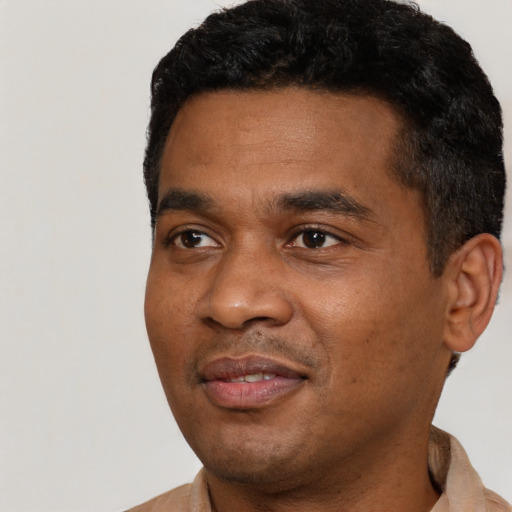 Joyful black young-adult male with short  black hair and brown eyes