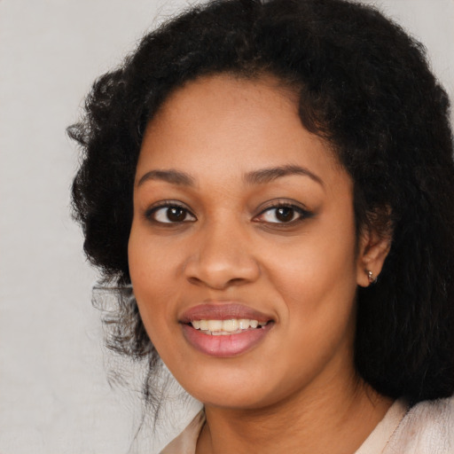 Joyful black young-adult female with long  black hair and brown eyes
