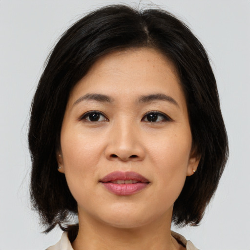 Joyful asian young-adult female with medium  brown hair and brown eyes