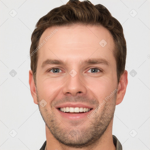 Joyful white young-adult male with short  brown hair and grey eyes