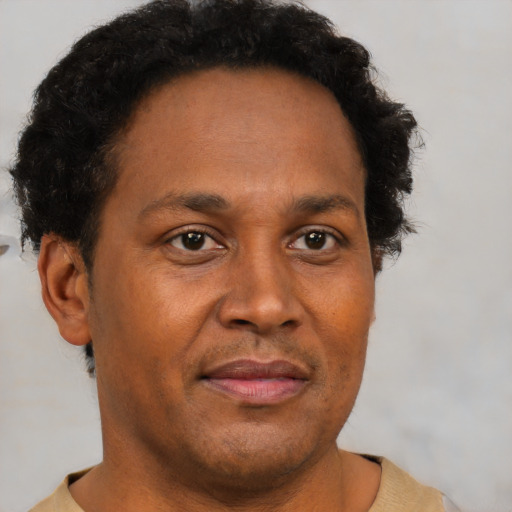 Joyful black adult male with short  brown hair and brown eyes