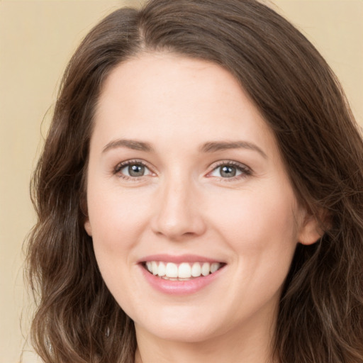 Joyful white young-adult female with long  brown hair and brown eyes