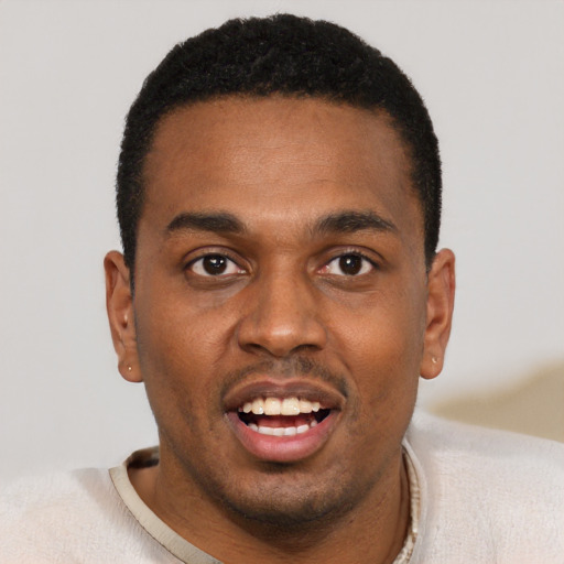 Joyful black young-adult male with short  black hair and brown eyes