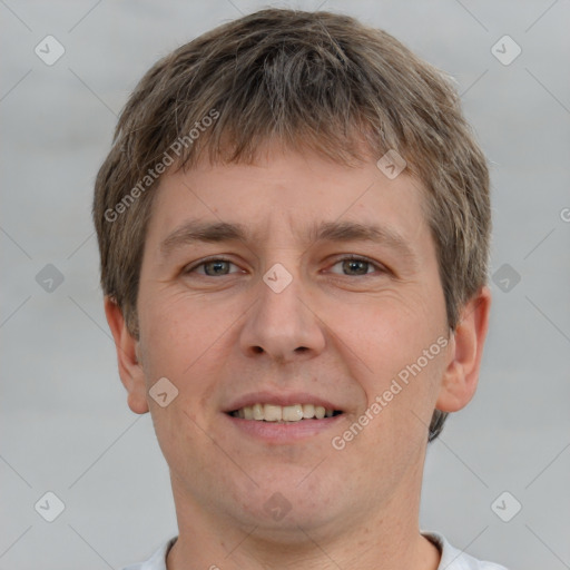 Joyful white young-adult male with short  brown hair and grey eyes