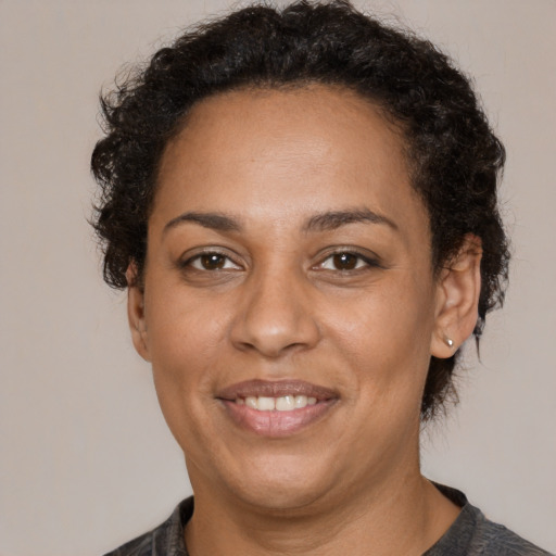 Joyful black adult female with short  brown hair and brown eyes