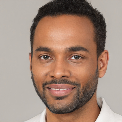 Joyful black young-adult male with short  black hair and brown eyes