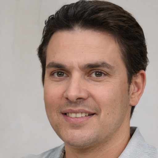 Joyful white adult male with short  brown hair and brown eyes