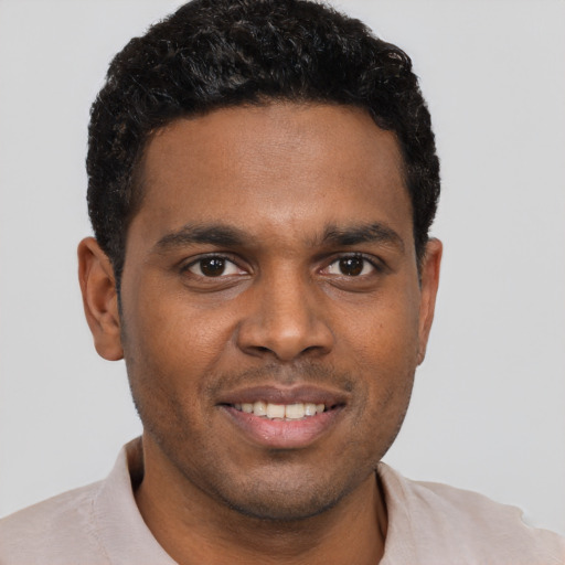 Joyful black young-adult male with short  brown hair and brown eyes