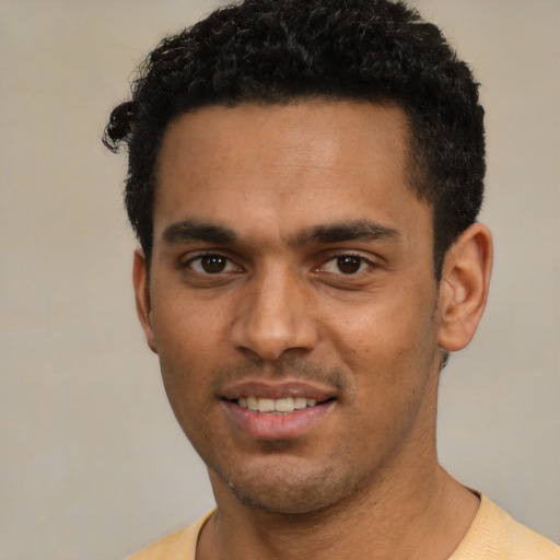 Joyful latino young-adult male with short  black hair and brown eyes