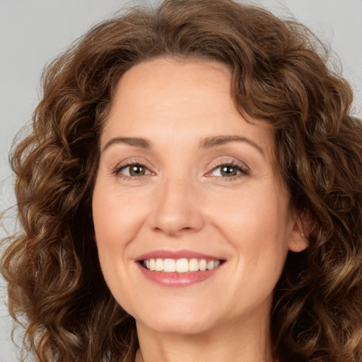 Joyful white adult female with long  brown hair and brown eyes