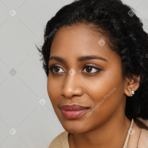 Joyful black young-adult female with long  black hair and brown eyes