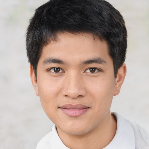 Joyful asian young-adult male with short  brown hair and brown eyes
