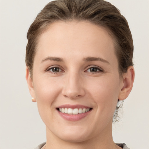 Joyful white young-adult female with medium  brown hair and grey eyes