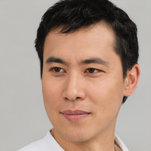 Joyful asian young-adult male with short  black hair and brown eyes
