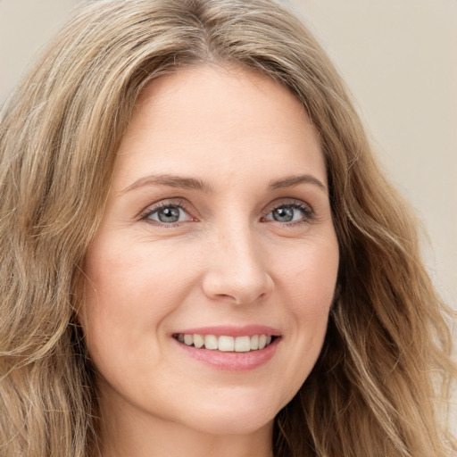 Joyful white young-adult female with long  brown hair and green eyes