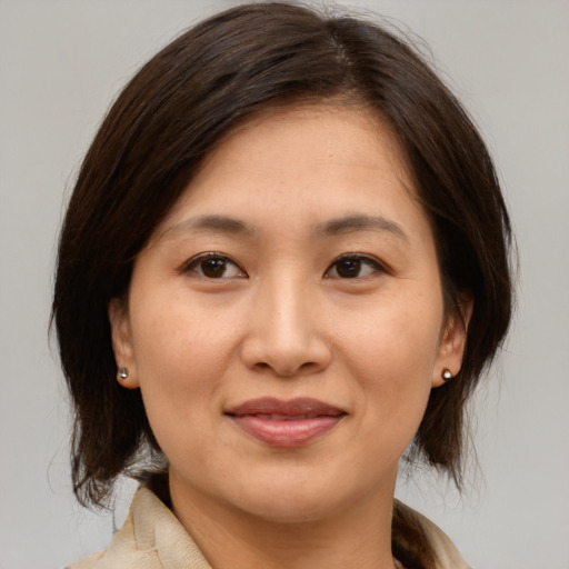 Joyful asian young-adult female with medium  brown hair and brown eyes