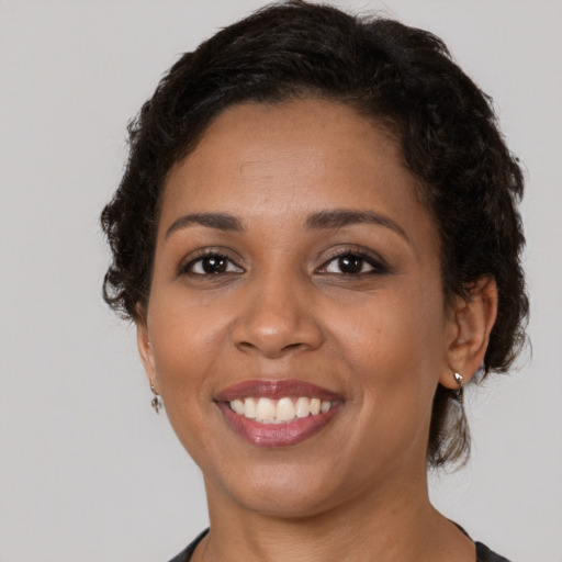 Joyful black young-adult female with short  brown hair and brown eyes