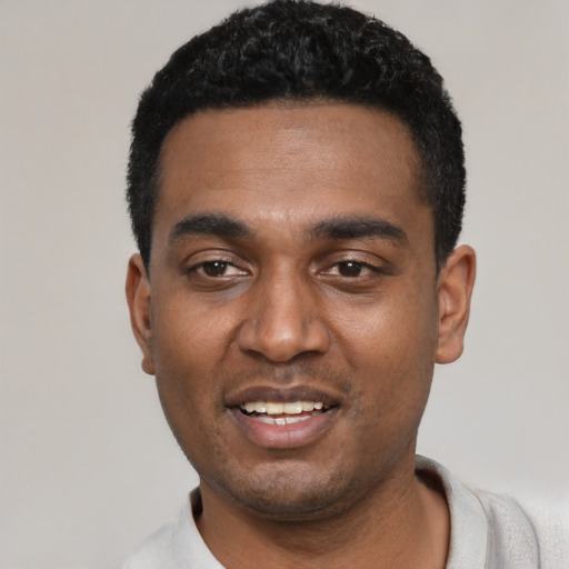 Joyful black young-adult male with short  black hair and brown eyes