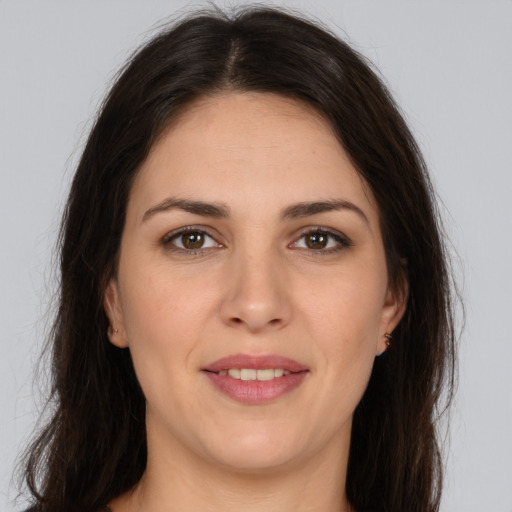 Joyful white young-adult female with long  brown hair and brown eyes