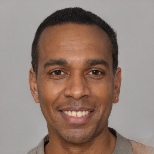 Joyful latino adult male with short  black hair and brown eyes