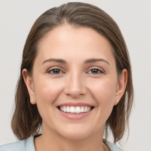 Joyful white young-adult female with medium  brown hair and grey eyes