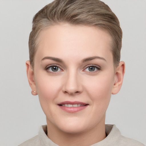 Joyful white young-adult female with short  brown hair and grey eyes