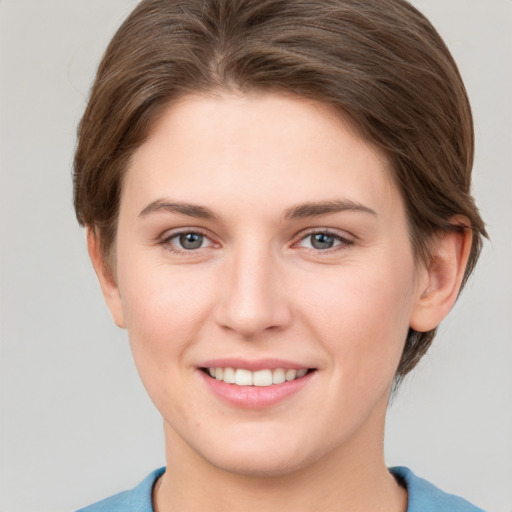 Joyful white young-adult female with short  brown hair and grey eyes