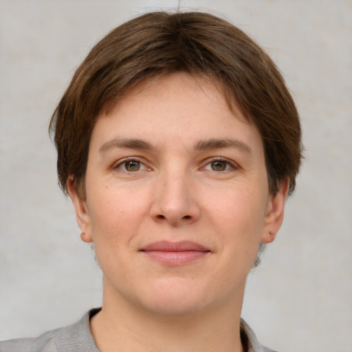 Joyful white young-adult female with short  brown hair and grey eyes