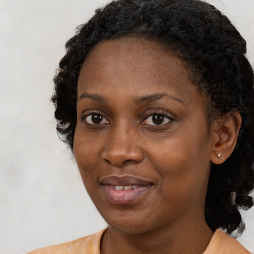 Joyful black young-adult female with medium  black hair and brown eyes