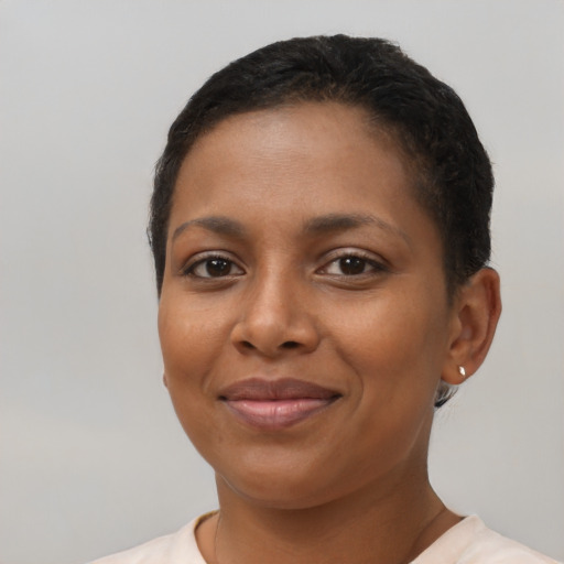 Joyful black young-adult female with short  brown hair and brown eyes