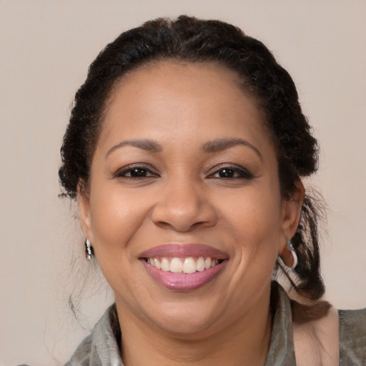 Joyful latino adult female with medium  brown hair and brown eyes